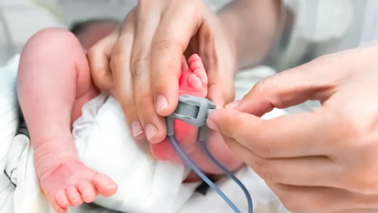 Recém-nascido com oxímetro no pé sendo monitorado em UTI neonatal após restrição de crescimento fetal